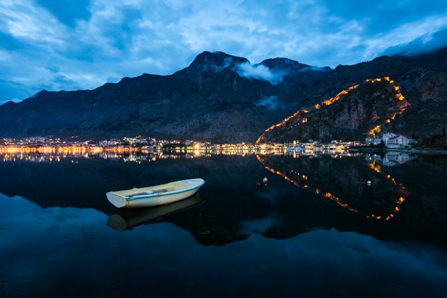 The evening view over the bay towards Kotor’s old town with the fortress lit up 