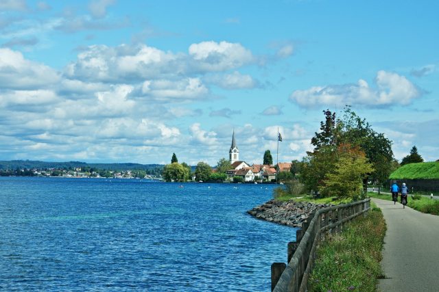 Cyclist on the path and church in Berlingen